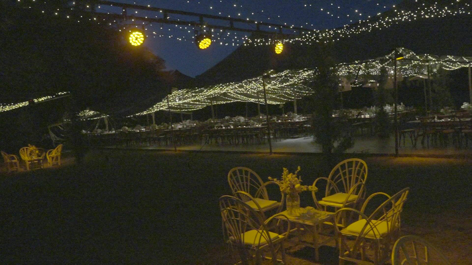 Manto de luces cálidas sobre las mesas en casamiento nocturno en Martindale, Pilar