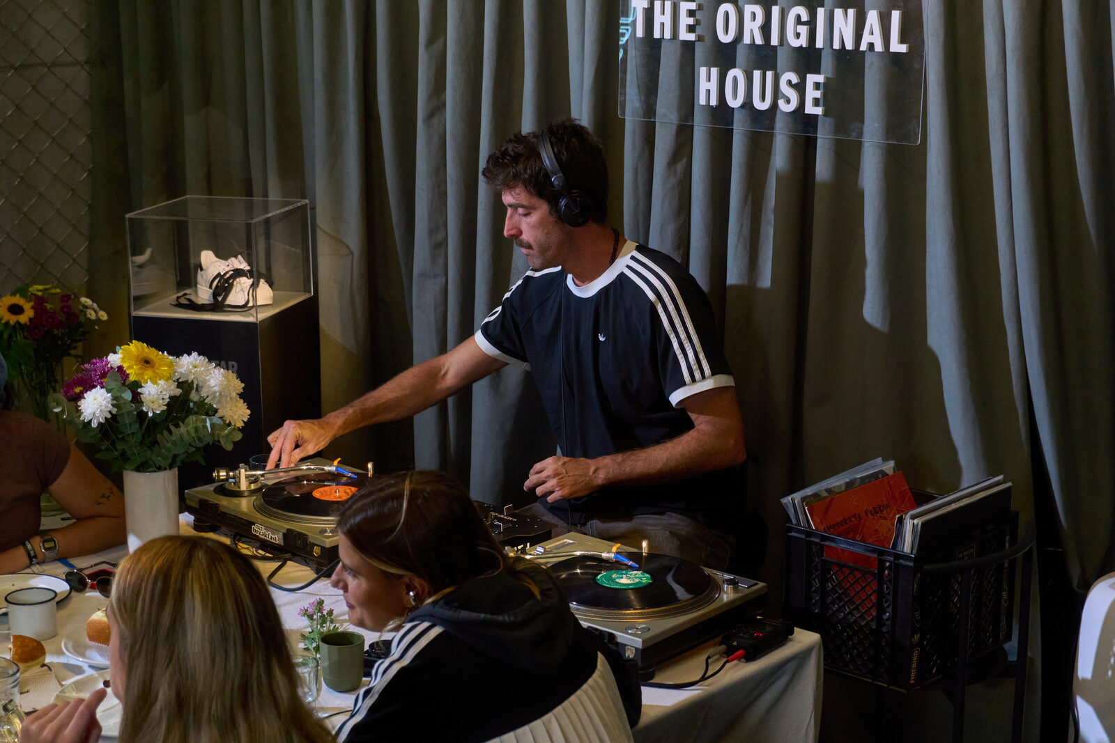 Pedro Etcheverry tocando vinilos en activación de Adidas The Original House con zapatilla Superstar en vitrina