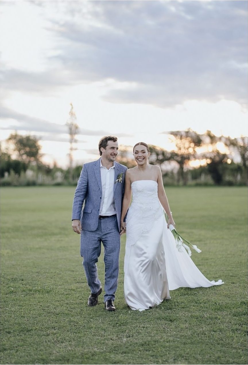 Novios caminando de la mano por el parque al atardecer en su casamiento al aire libre en Buenos Aires